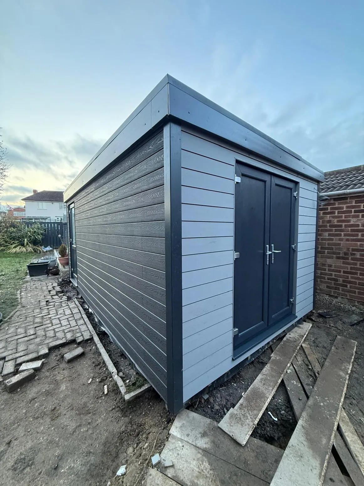 Contemporary garden room with dark timber-style cladding